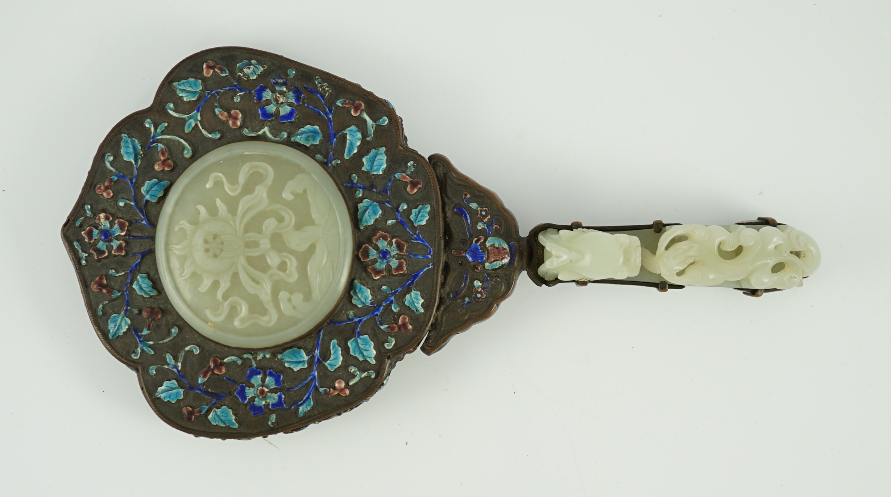 An early 20th century Chinese enamelled copper hand mirror with 18th/19th century Chinese pale celadon jade mounts